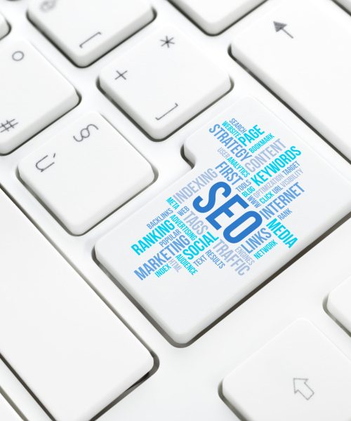 Seo business, search engine optimization, concept cloud in enter button or key on white keyboard